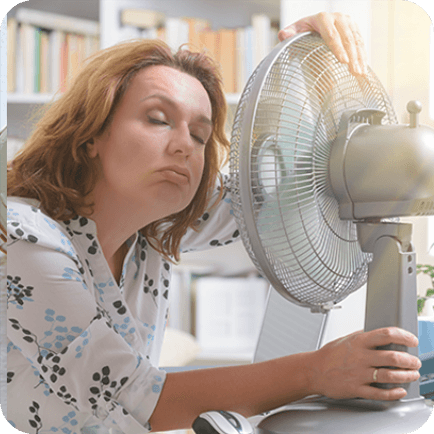 Woman cooling off next to a fan